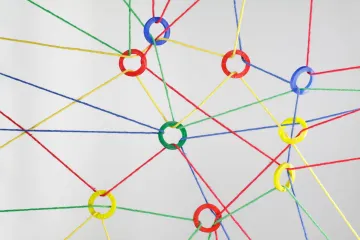 Multicolored strings tied together with different colored rings in red, blue, green or yellow making a web of connections..